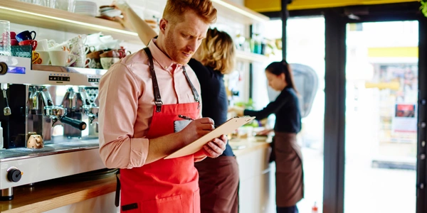Cafe employee reviewing employee wellbeing strategy memo